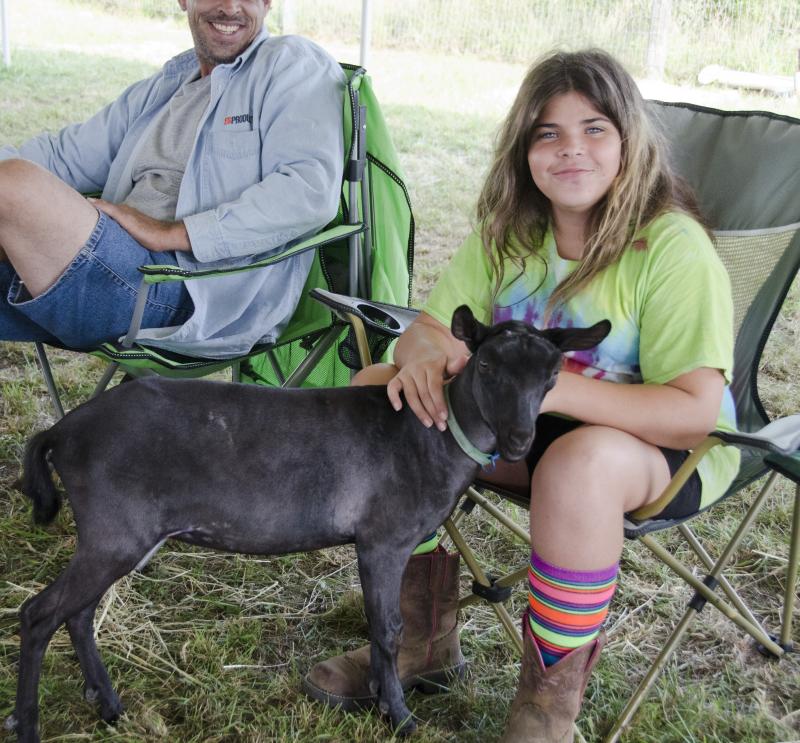 Kayli Rosa, 11, pets her goat, Magic. Kayli and her family run East Coast Livestock in Bristol County and brought a bounty of goats to the fair. BY GEORGIA SPARLING